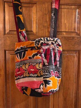 Multi-colored patchwork tote bag with floral and geometric designs in orange